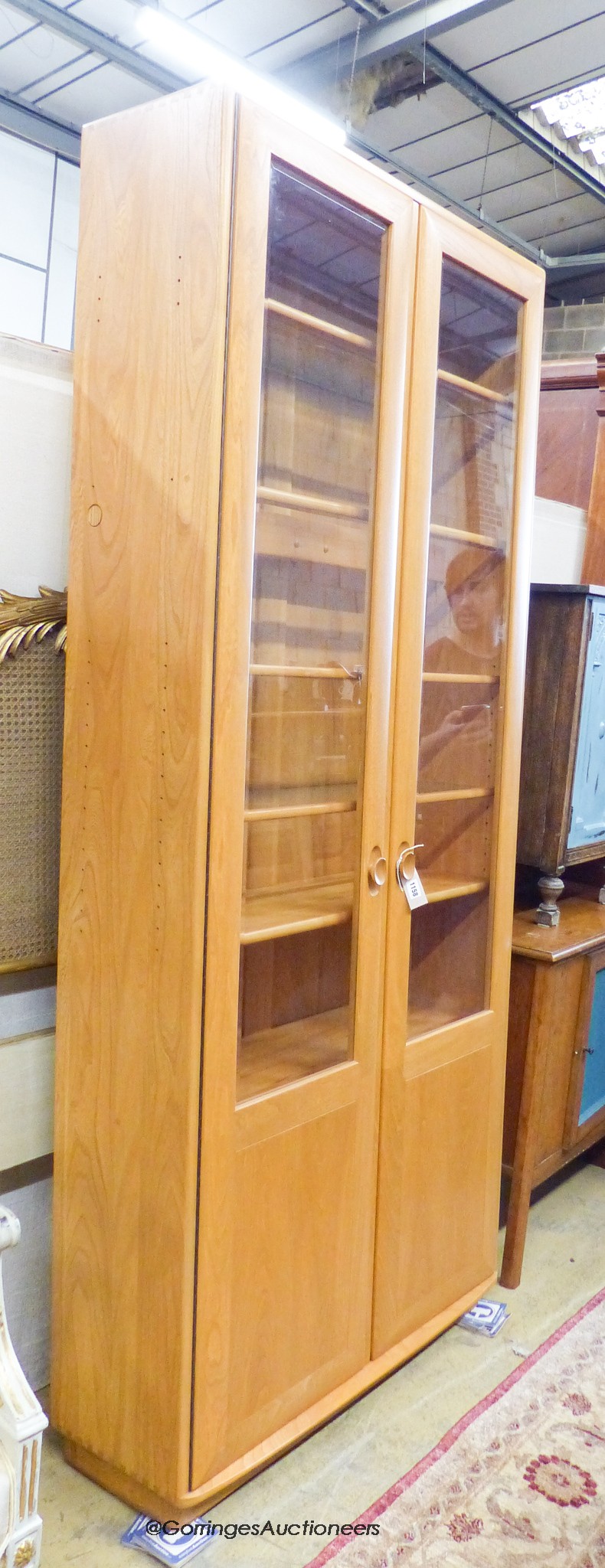 An Ercol Windsor elm two door display cabinet, width 91cm, depth 32cm, height 206cm